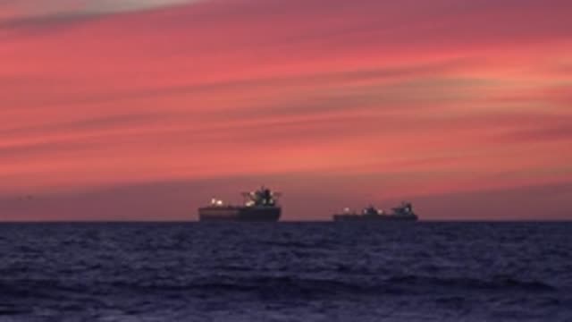 HUNTINGTON BEACH CALIFORNIA-2020: Pretty Orange Sky Two Ships In Distance On