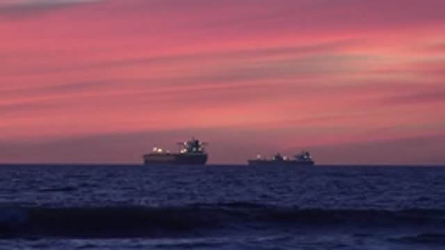 HUNTINGTON BEACH CALIFORNIA-2020: Two Ships With Deck Lights Blazing Sit At Anchor