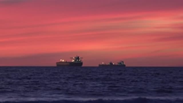 HUNTINGTON BEACH CALIFORNIA-2020: Two Freighter Ships In The Ocean At Sunset