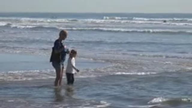HUNTINGTON BEACH CALIFORNIA-2020: Adult Female And Child Placing Their Feet In