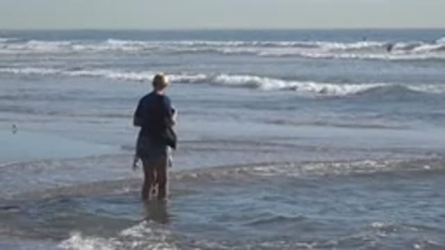 HUNTINGTON BEACH CALIFORNIA-2020: Child And Grandmother Wading Along The Ocean
