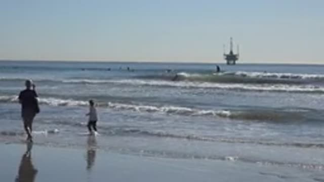 HUNTINGTON BEACH CALIFORNIA-2020: A Parent And A Daughter Are Walking At The Beach