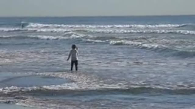 HUNTINGTON BEACH CALIFORNIA-2020: Little Girl Walks Through The Shallow Area Of