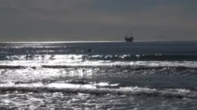 HUNTINGTON BEACH CALIFORNIA-2020: Waves Crashing Onto The Beach While A Large