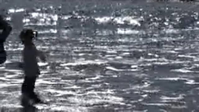 HUNTINGTON BEACH CALIFORNIA-2020: A Girl In A White T-Shirt Playing In The Waves