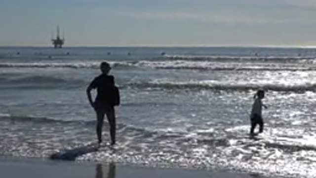 HUNTINGTON BEACH CALIFORNIA-2020: Kid With Man On Beach Platform