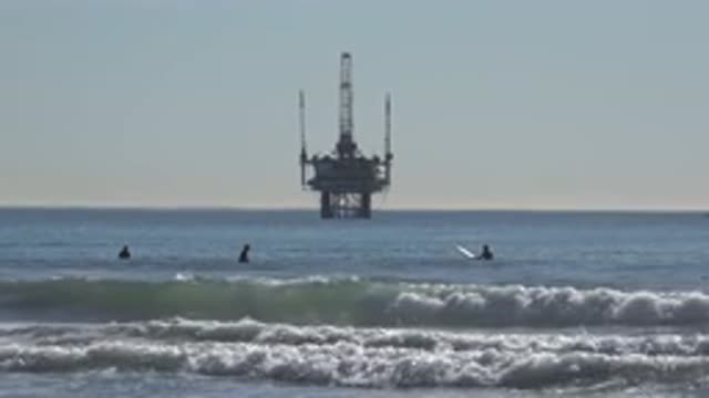 HUNTINGTON BEACH CALIFORNIA-2020: Surfers Wait For A Wave In Water Near The Shore