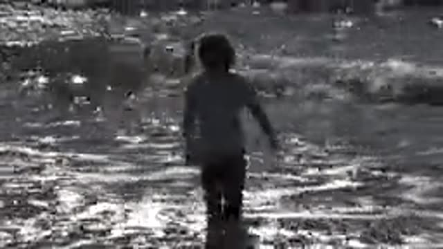 HUNTINGTON BEACH CALIFORNIA-2020: A Young Girl With Pigtails Stands In Shallow Water