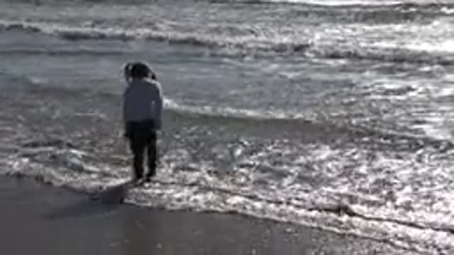 HUNTINGTON BEACH CALIFORNIA-2020: Little Girl Plays Jumping Waves On The Beach