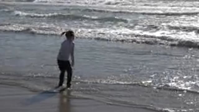 HUNTINGTON BEACH CALIFORNIA-2020: Young Girl Plays In The Beach Next To The Waves