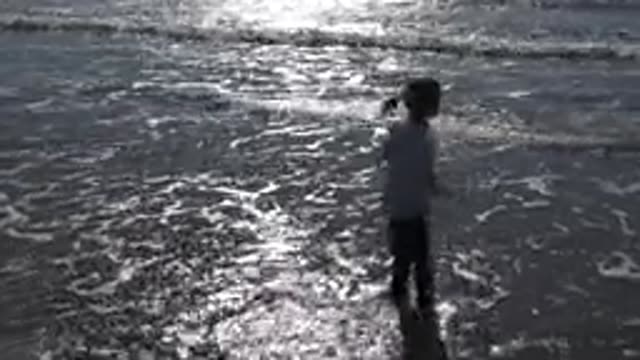 HUNTINGTON BEACH CALIFORNIA-2020: Child Jumps And Splashes In The Ocean And