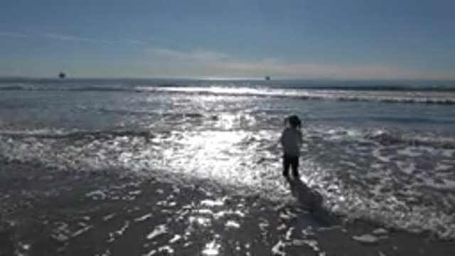 HUNTINGTON BEACH CALIFORNIA-2020: Little Young Girl Jumps on Beach for First Time