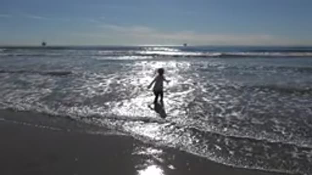 HUNTINGTON BEACH CALIFORNIA-2020: A Little Girl Is Jumping On The Beach On A Sunny Day