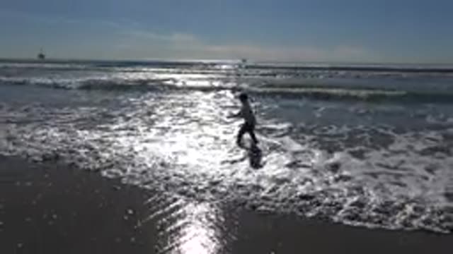 HUNTINGTON BEACH CALIFORNIA-2020: Little Girl Playing In The Surf As The Waves