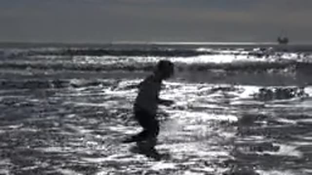 HUNTINGTON BEACH CALIFORNIA-2020: Little Girl Shoeless Dancing In The Ocean At A