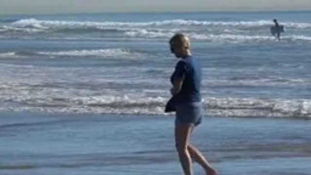 HUNTINGTON BEACH CALIFORNIA-2020: A Pretty Lady Is Walking Around On The Beach