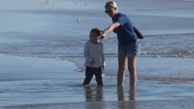 HUNTINGTON BEACH CALIFORNIA-2020: Woman And Child On An Empty Beach With A Lot