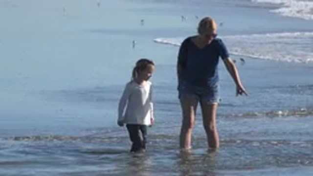 HUNTINGTON BEACH CALIFORNIA-2020: Mother Daughter Exploring Ocean in Shallow Water