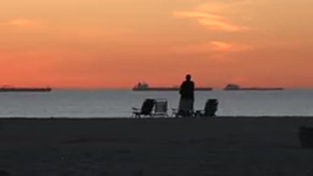 HUNTINGTON BEACH CALIFORNIA-2020: A Couple On A Beach During Sunset One Standing