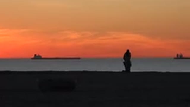 HUNTINGTON BEACH CALIFORNIA-2020: Surfer Collects His Gear On The Beach At Sunset