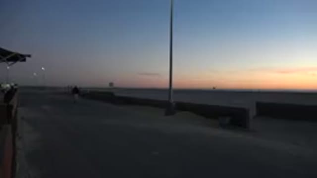 HUNTINGTON BEACH CALIFORNIA-2020: Person Walking Barefoot On Sand At Dusk