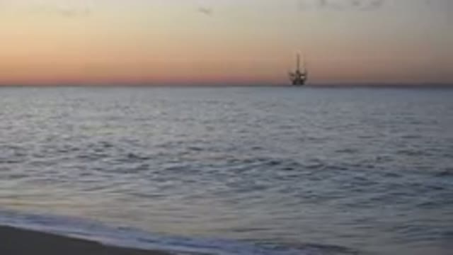 HUNTINGTON BEACH CALIFORNIA-2020: Pale Pink Sky Waves Gently Break On Shore