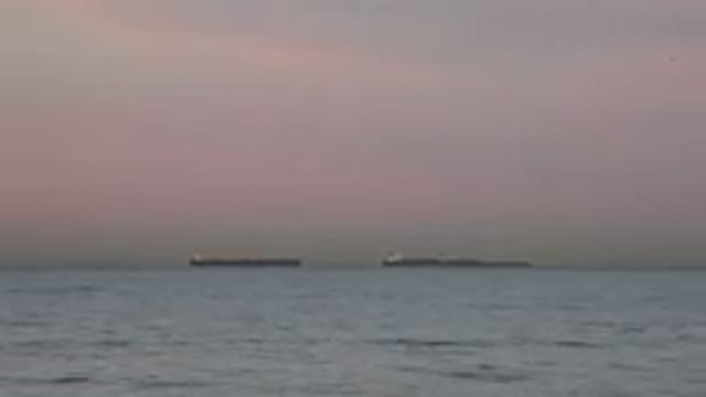HUNTINGTON BEACH CALIFORNIA-2020: Two Big Ships Far Out At Sea With Cloudy Sky