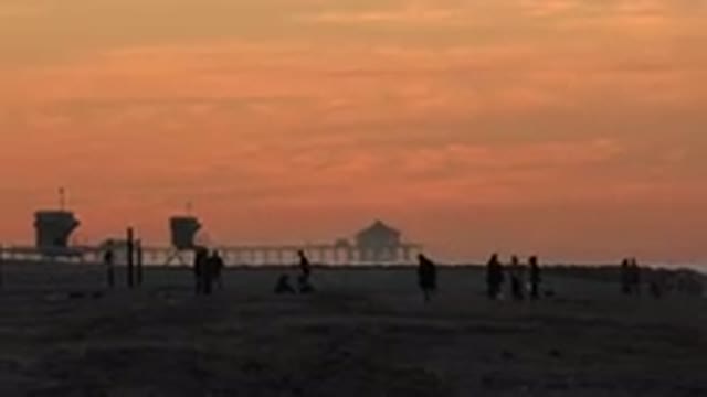 HUNTINGTON BEACH CALIFORNIA-2020: Many People Playing On The White Beach At Sunset