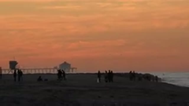 HUNTINGTON BEACH CALIFORNIA-2020: People Strolling The Beach At Sunset