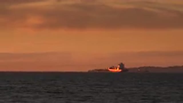 HUNTINGTON BEACH CALIFORNIA-2020: A Boat Out At Sea Is Overlooking The Beautiful Sunset