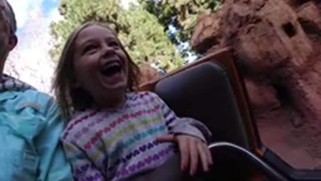 DISNEYLAND CALIFORNIA-2020: Girl Wearing White Striped Shirt Sits Next To Man