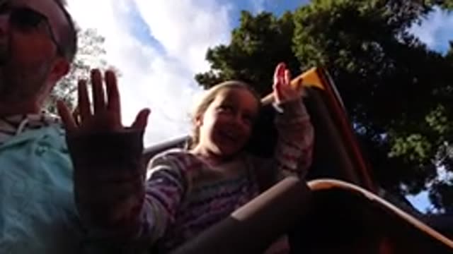 DISNEYLAND CALIFORNIA-2020: Man And Little Girl Ride Spinning Carnival Ride Past