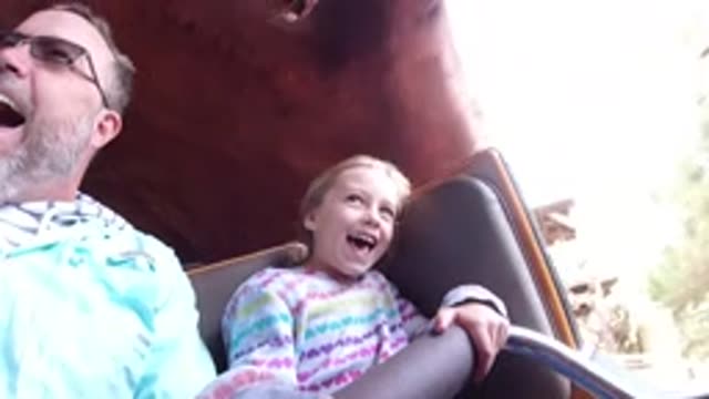 DISNEYLAND CALIFORNIA-2020: Girl Wearing White Striped Jacket Smiles While Sitting on Bench