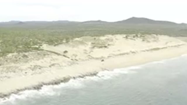 Aerial View Of Rugged Coastal Dunes And Ocean