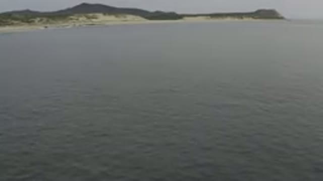 Aerial View Of Calm Sea And Distant Coastline