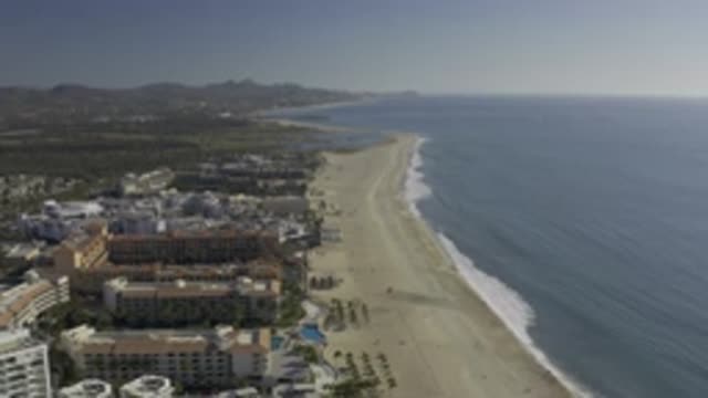 EAST CAPE BCS MEXICO-2019: Long Beach Blue Sea Many People Walking And Large Buildings
