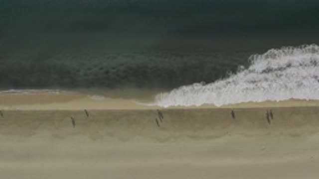 EAST CAPE BCS MEXICO-2019: View Of Large Wave Crashing On Tan Beach On A Cloudy Day
