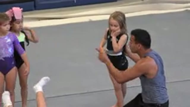 CABO SAN LUCAS MEXICO-2020: Male Adult Teaches Young Girls Gymnastics On Gray Mats
