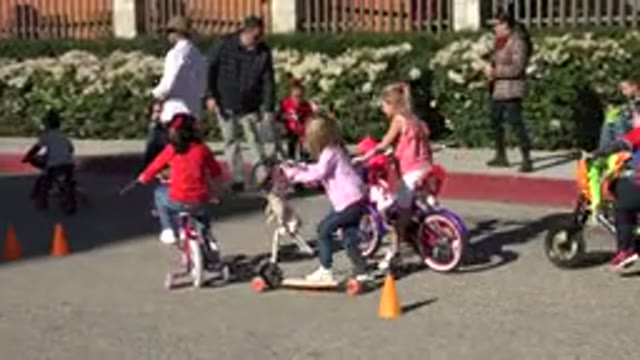 CABO SAN LUCAS MEXICO-2020: Children Ride Scooters And Bikes Down A Street