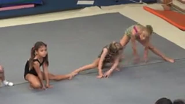 CABO SAN LUCAS MEXICO-2020: Row Of Little Girl Gymnasts Stretch Their Legs On