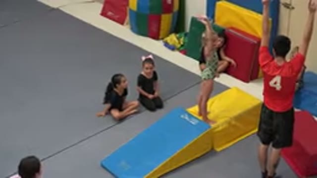CABO SAN LUCAS MEXICO-2020: Man In A Red Shirt Teaches A Young Girl In Green How To Flip