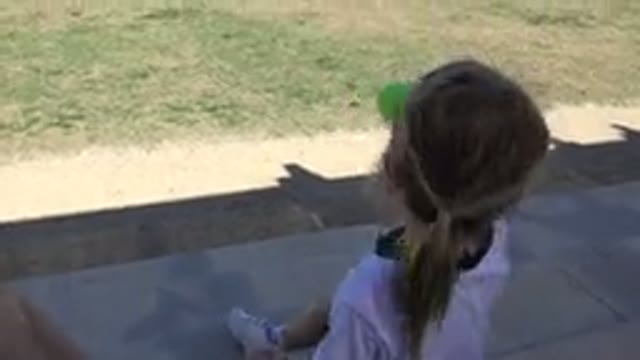 LOS CABOS MEXICO-2019: Young Girl Sitting On Pavement Overlooking Park While Drinking