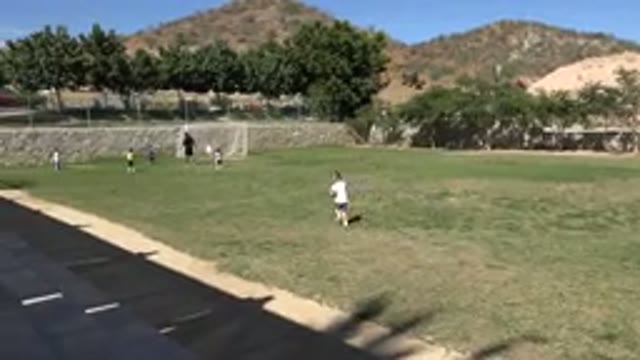 LOS CABOS MEXICO-2019: Child Running Across A Soccer Field With Other Kids