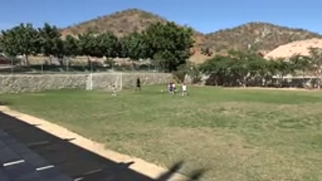 LOS CABOS MEXICO-2019: Young Children Playing Soccer In The Garden With An Adult