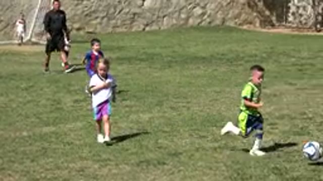 LOS CABOS MEXICO-2019: Little Boy in Green Soccer Suit Kicking Ball