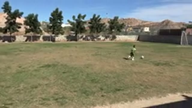 LOS CABOS MEXICO-2019: Little Boy Dribbling Soccer Ball on Grass Field in Sunny Day