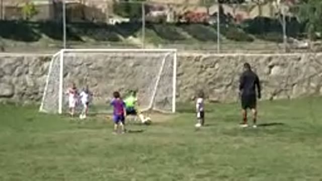LOS CABOS MEXICO-2019: Five Children Playing Soccer In A Field With An Adult