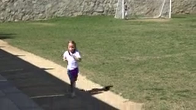 LOS CABOS MEXICO-2019: Little Girl Running On Sidewalk Next To Soccer Field