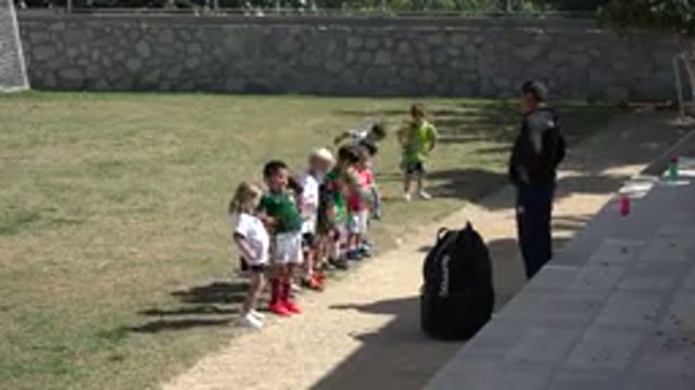 LOS CABOS MEXICO-2019: Kids Moving in Line on Grass Field Playing Football