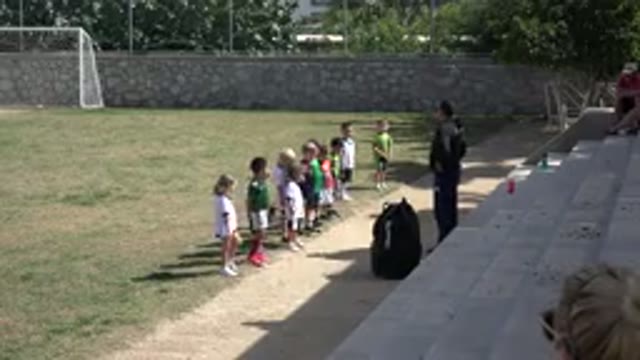 LOS CABOS MEXICO-2019: Many Small Children Dancing Around A Grass Soccer Field